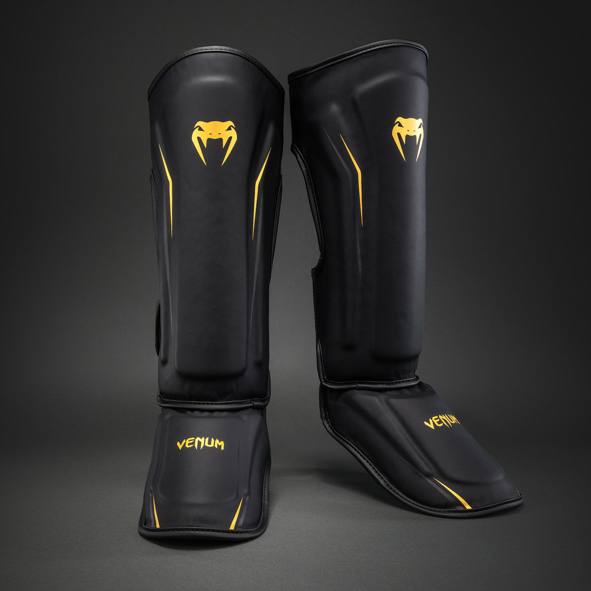 Venum G-Core Espinilleras - Negro/Oro