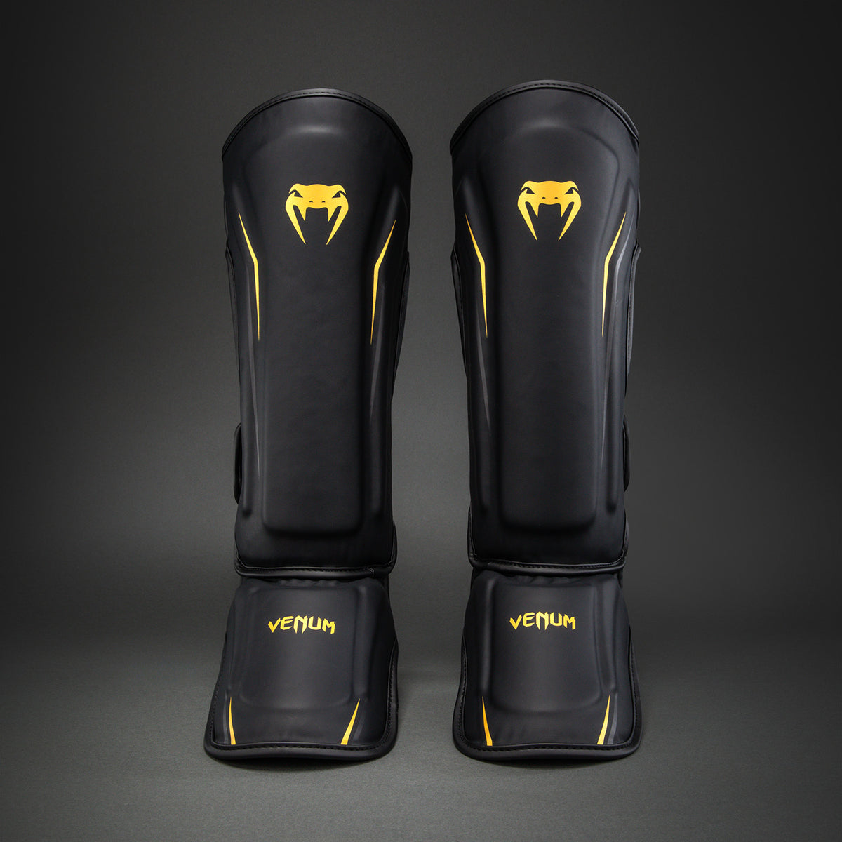 Venum G-Core Espinilleras - Negro/Oro