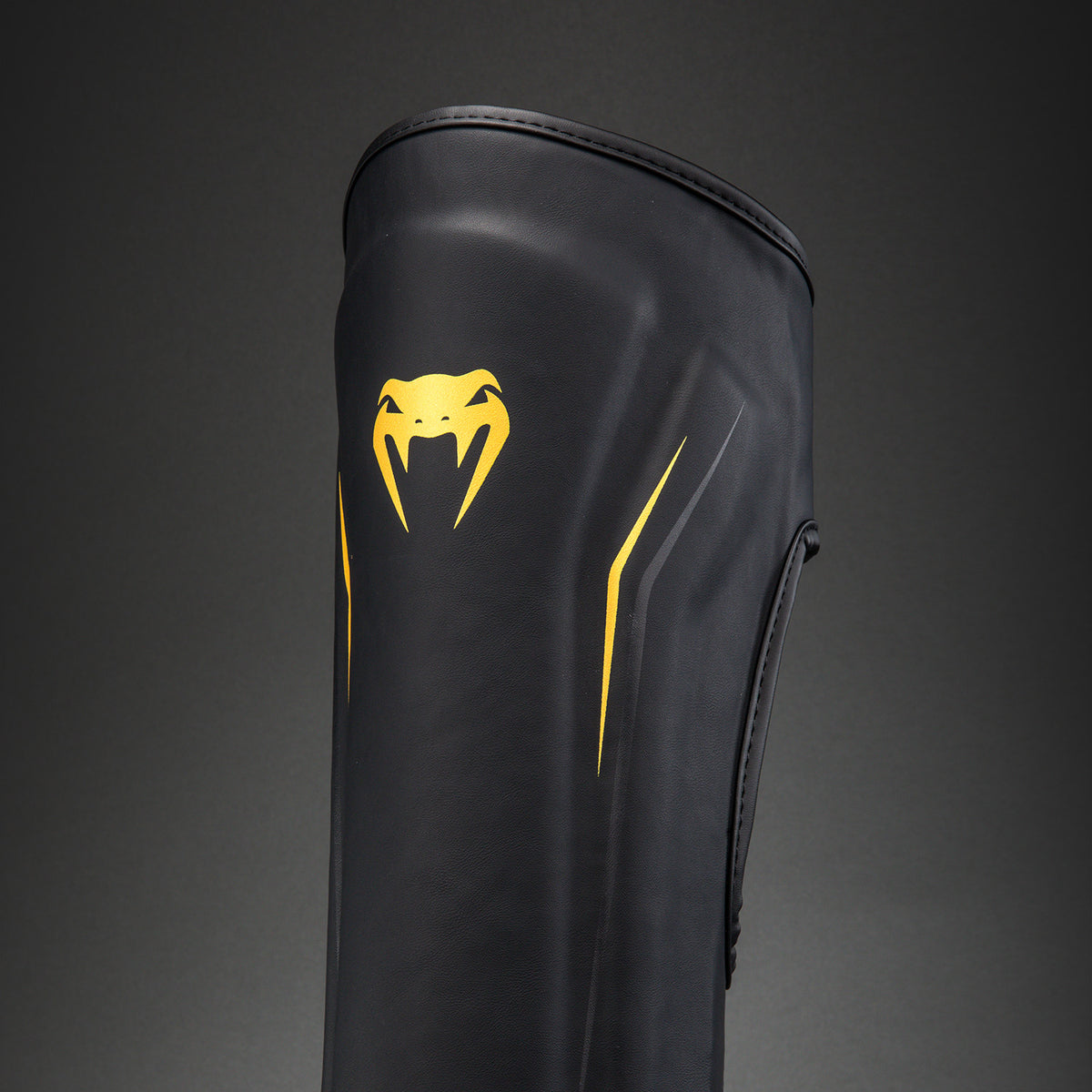 Venum G-Core Espinilleras - Negro/Oro